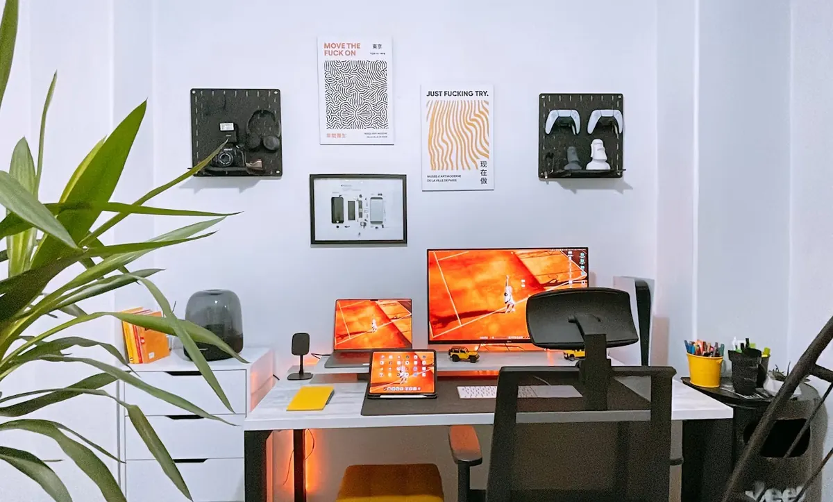 A tidy workspace with a desktop monitor, a laptop and plants