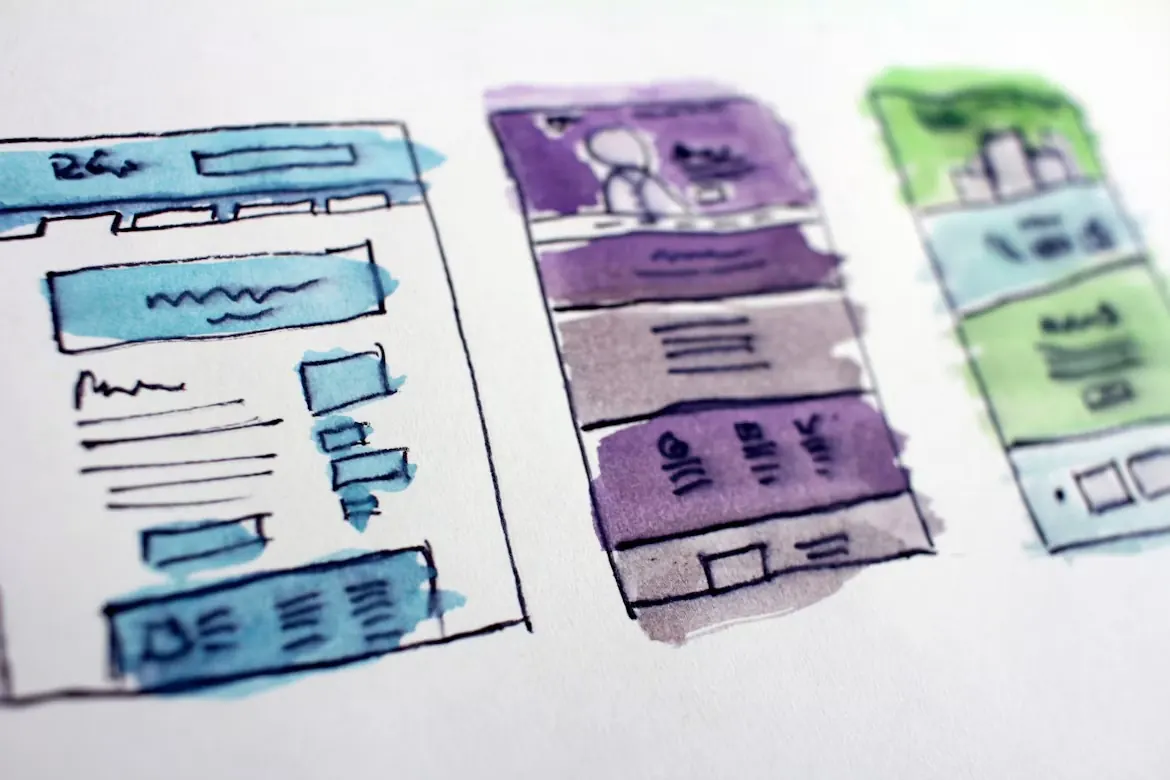 Watercolour wireframe sketches of website layouts on paper